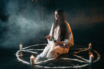 Woman holds burnt rose in hands, dark magic ritual