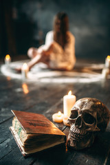 Human skull and spellbook,  occultism and exorcism