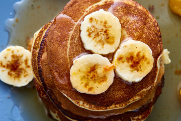 Pile of homemade pancakes with honey and walnuts on rustic wooden background, selective focus
