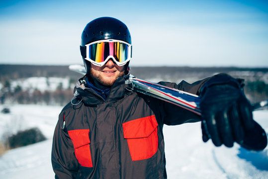 Skier holds skis and poles in hands