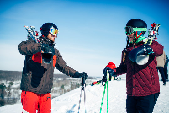 Male and female skiers poses with skis and poles