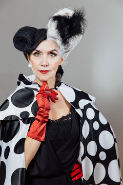 Stylish adult woman in the image of the heroine of the film. Cloak cape from puppies dolmatinians.