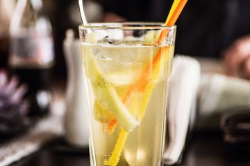 Lemon drink with carbonated water and straw in glass.
