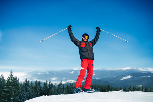 Male skier hands up on the top of mountain