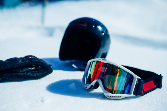 Helmet, glasses and gloves on the snow closeup