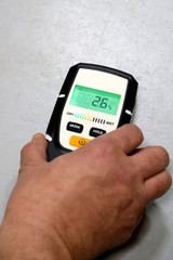 Man using moisture meter for house inspection. 