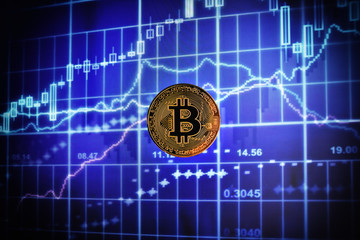 coin bitcoin against the background of the monitor with exchange rate quotes