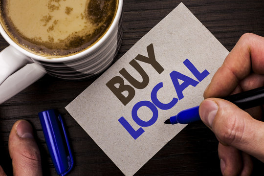 Conceptual hand writing showing Buy Local. Business photo text Buying Purchase Locally Shop Store Market Buylocal Retailers written Man Holding Marker on Note Paper Wooden background Coffee.