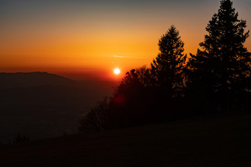 Fototapeta na wymiar Sonnenuntergang mit Bäumen im Vordergrund