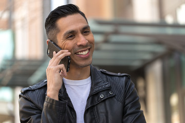 Hispanic man in city talking on cell phone