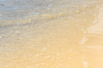 Coast of the sea on a sunny day with blue waves and yellow sand - the concept of relaxation