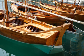 Fototapeta na wymiar Fragments of wooden sailing yachts moored at the waterfront.