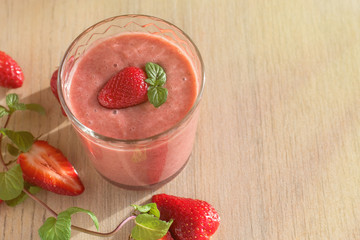 Strawberry Banana Smoothies in Glasses with Ingredients on light wooden Table