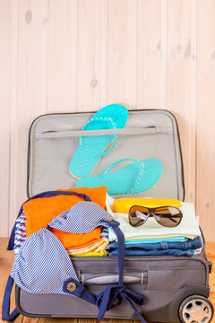 stuffed small suitcase with women's things for a holiday at sea close up