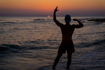 bodybuilder posing at sunset