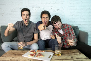 young group of happy and excited men watching a football game on the couch