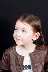 Cheerful little girl isolated on black studio shot