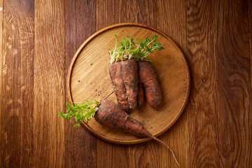 Artistically served vegetable salad with carrot, cucumber, letucce over wooden background, selective focus