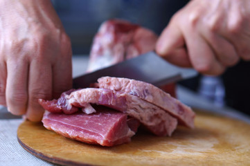 A woman is cutting meat
