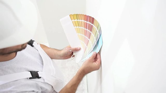 painter man at work choice color with swatches samples, wall painting concept, white copy space background