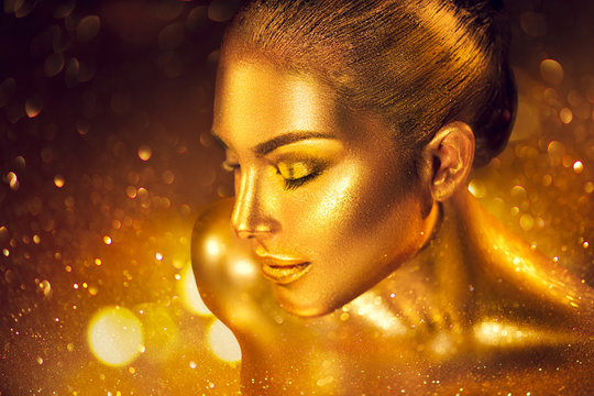 Fototapeta Fashion art golden skin woman portrait closeup. Gold, jewelry, accessories. Model girl with golden glamour shiny makeup
