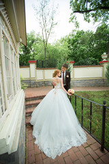 beautiful loving young couple groom and bride walking in summer park