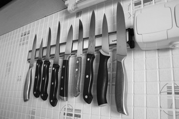kitchen knives hanging on a magnetic holder on the wall