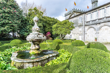 Spanien - Barocker Brunnen mit Buchsbaumhecke und Kamelienbaum im Pazo de Oca in Valboa in Galcien