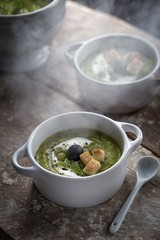 Delicious pea cream soup on the rustic background