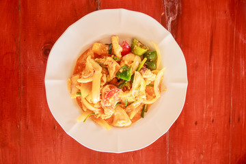 Thai traditional food, Stir fried squid with salted egg on wooden table background.