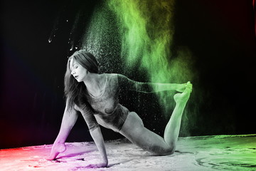 Obraz na płótnie Canvas Slender blonde dancing in white dust studio shot