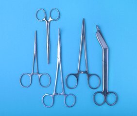 surgical instruments and tools including scalpels, forceps and tweezers arranged on a table for a...