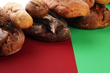 Different kinds of bread and bread rolls on board from above. Kitchen or bakery poster design