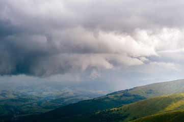 Storm rainy clouds above mountains. Apocalypse fantasy fabulous sky. Beautiful windy dramatic cloudscape at nature. Picturesque scenic view outdoor. Travel in wild territory. Discover rocky hills.