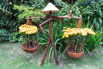 Mensch aus Holz als Dekoration und  Blumenständer im Garten.