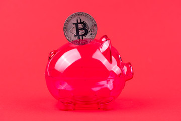 Sparbüchse mit einem Bitcoin vor roten Hintergrund