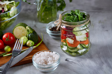 Fresh vegetable salad and ripe veggies on cutting board over white background, close up, selective focus
