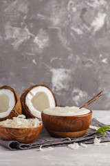 Coconut yogurt in a wooden bowl on a dark background, copy space. Healthy vegan food concept.