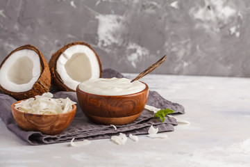 Coconut yogurt in a wooden bowl on a dark background, copy space. Healthy vegan food concept.