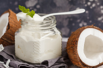 Coconut yogurt in a glass jar on a dark background, copy space, macro. Healthy vegan food concept.