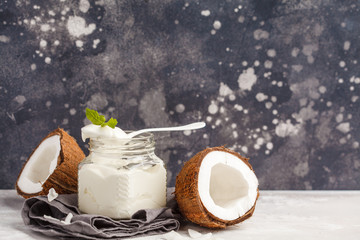 Coconut yogurt in a glass jar on a dark background, copy space, macro. Healthy vegan food concept.