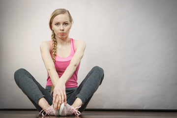Sad depressed young teenage girl sitting by wall