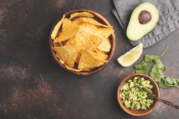 Mexican food concept. Nachos - yellow corn totopos chips with guacamole, frame of food, top view, copy space.