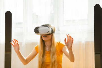 Girl wearing virtual reality goggles at home