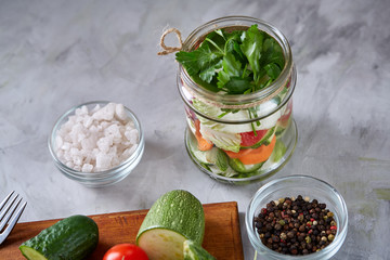 Fresh vegetable salad and ripe veggies on cutting board over white background, close up, selective focus