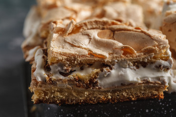 Norwegian Cake with meringue and whipped cream, dark background