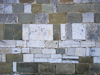Old wall with many types of stone.