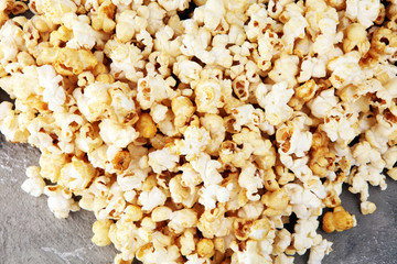 Salt popcorn or sweet popcorn on old grey background.