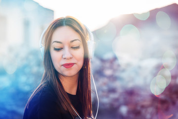 portrait of a pretty young woman with blue eyes and red lips listening to music with her headphones