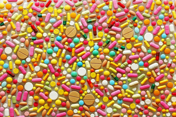 A lot of colorful pills on a grey background